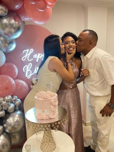 Celebración de quince años en el restaurante Rancho del Sol con pastel rosa, decoración de globos y una quinceañera feliz junto a sus padres.