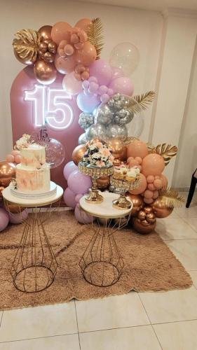 Decoración elegante para fiesta de 15 años con globos metálicos, pastel temático y mesa de dulces en el restaurante Rancho del Sol.